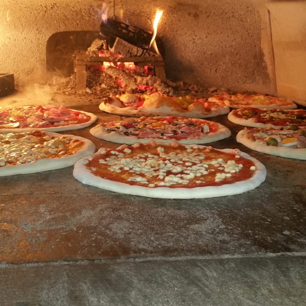 Pizzen backen im holzbefeuerten Steinofen