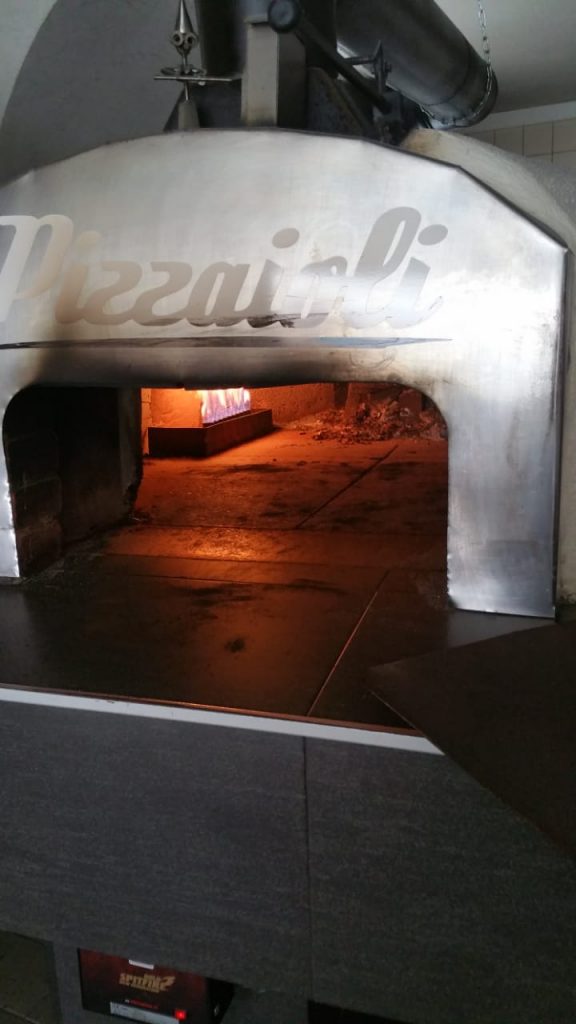 Mobiler Steinofen mit Pizzaioli-Schriftzug und brennendem Feuer